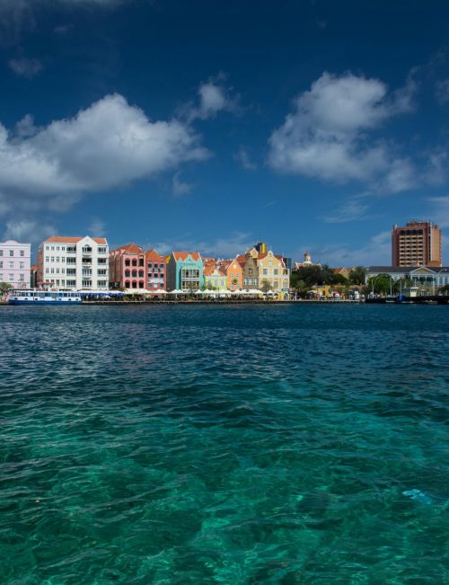 Scenic view of vibrant colonial buildings lining the harbor in Willemstad, Curacao.